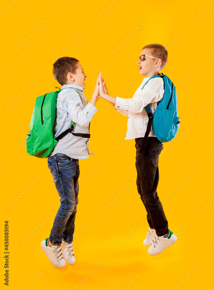 Jumping emotional schoolboys on the yellow background Jumping emotional schoolboys on the yellow background