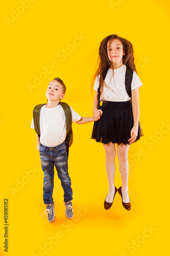 Brother and sister are jumping and holding hands