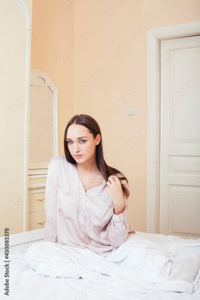 Sexy beautiful brunette woman lying in bed sensual, looking at camera. Seduction concept in luxury room interior Sexy beautiful brunette woman lying in bed sensual, looking at camera. Seduction concept in luxury room interior