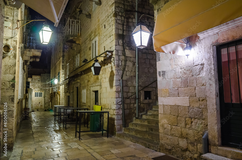 Cozy street and old city walls at night in Dubrovnik, Croatia