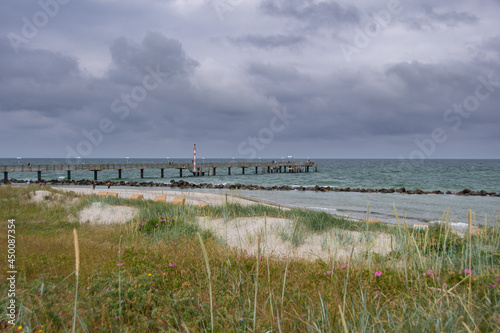 Fototapeta Naklejka Na Ścianę i Meble -  The view from the dunes to the Wustrow pier and the Baltic Sea