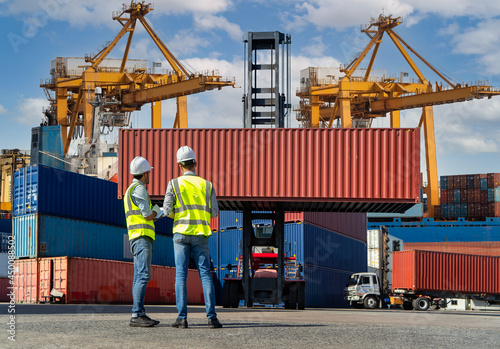 Engineers are overseeing the transportation of cargo with containers inside the warehouse. Container in export and import business and logistics.