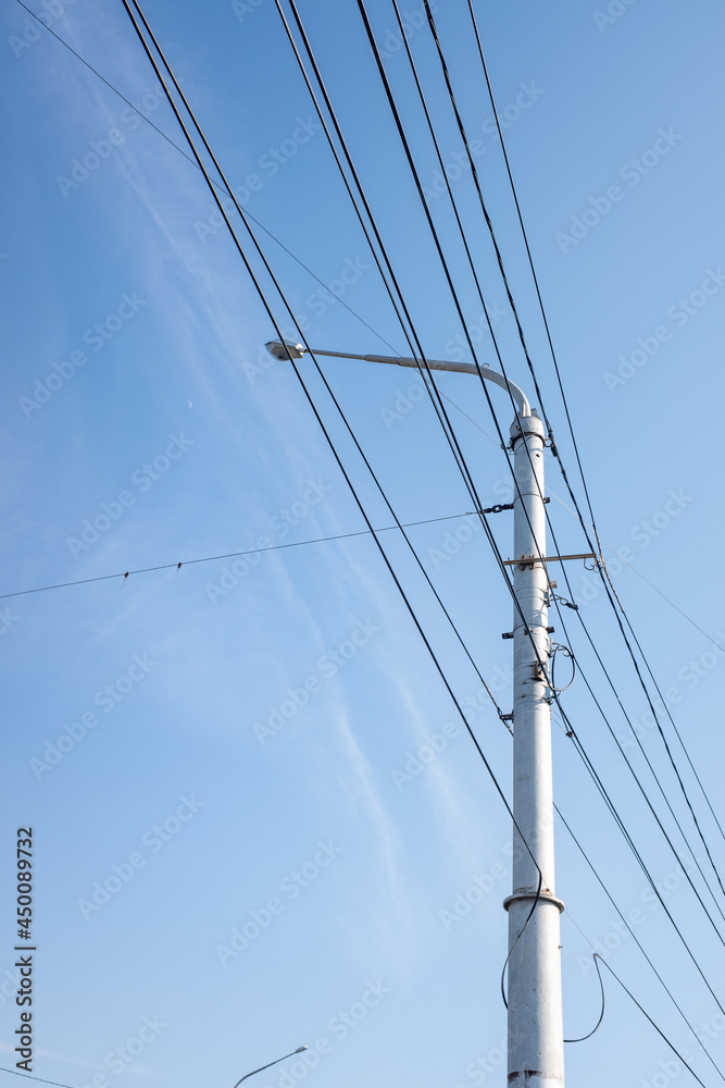 Electric pole with wires, against the background of the sky.