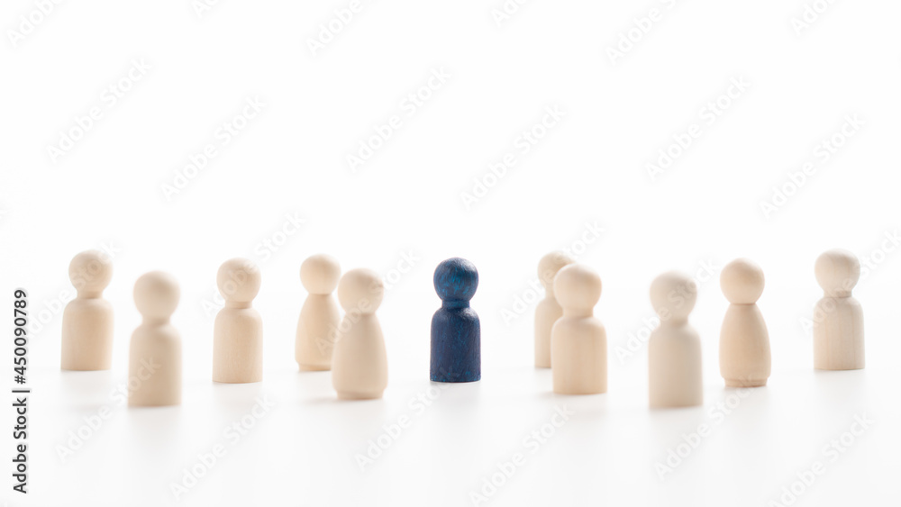 A wooden figure standing with a team to influence and empower. Concept of leadership, successful competition winner and Leader with influence and Social distancing for a new normal lifestyle A wooden figure standing with a team to influence and empower. Concept of leadership, successful competition winner and Leader with influence and Social distancing for a new normal lifestyle
