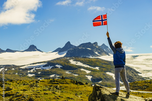Tourist with norwegian flag in mountains photo