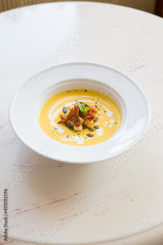 Fresh yellow pumpkin soup served with croutons