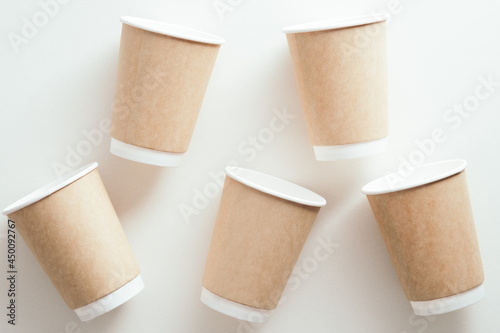 Takeaway paper cups of coffee on white background. Flat lay, top view.