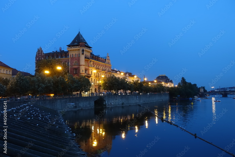 sunset and night view near Charles Bridge with river view and reflection, a medieval stone arch bridge that crosses the Vltava (Moldau) river, Prague, Czech Republic