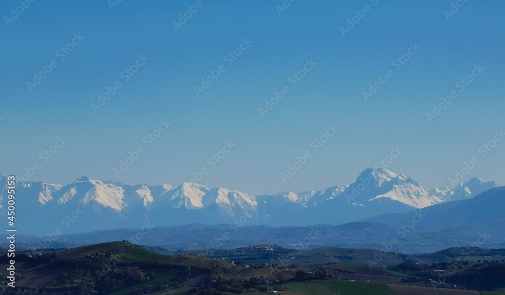 Cime innevate valli e colline dei monti appennini nel cielo azzurro di una giornata primaverile Cime innevate valli e colline dei monti appennini nel cielo azzurro di una giornata primaverile
