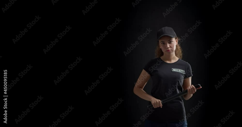 Female African-American security guard with baton on dark background Female African-American security guard with baton on dark background