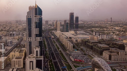 Aerial top view of highway junction with traffic timelapse in Dubai, UAE at sunset. Famous Sheikh Zayed road in Dubai downtown. Transportation and driving concept view from rooftop. photo