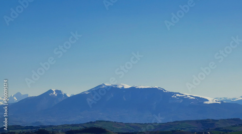 Cime innevate valli e colline dei monti appennini nel cielo azzurro di una giornata primaverile