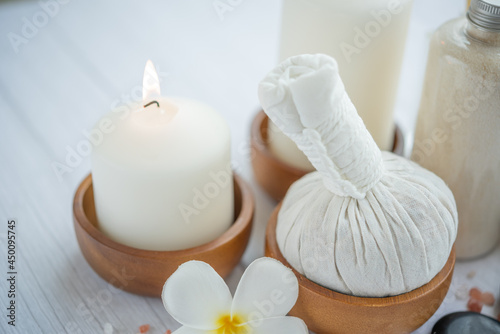 Natural relaxing spa composition on massage table in wellness center    with towels  flowers and salt  candle  on massage table in spa salon.