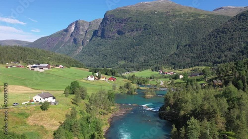 Lake bottom Loenvatnet with glacial river starting to flow dowm Lodalen valley - Forward moving aerial photo