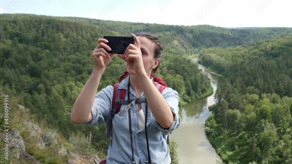 Happy woman with a tourist backpack looking through binoculars at a beautiful landscape. Happy woman with a tourist backpack looking through binoculars at a beautiful landscape.
