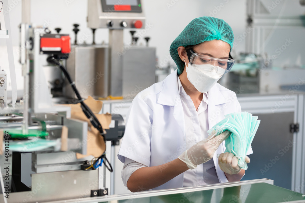 woman factory worker are producing medical face masks, counting and checking of quality from machine woman factory worker are producing medical face masks, counting and checking of quality from machine