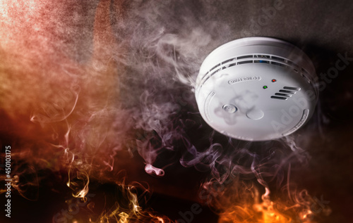 Smoke detector and fire alarm in action background photo