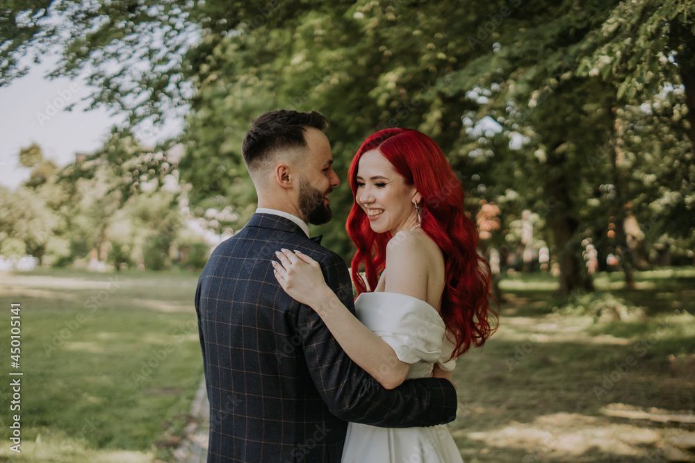 Fototapeta premium Wedding day. Happy bride and groom hugging and laughing Red hair diversity