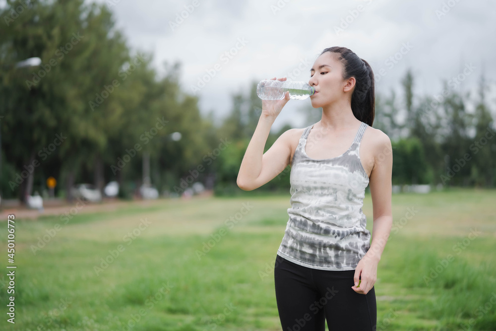 Asian women drink water after exercising Asian women drink water after exercising