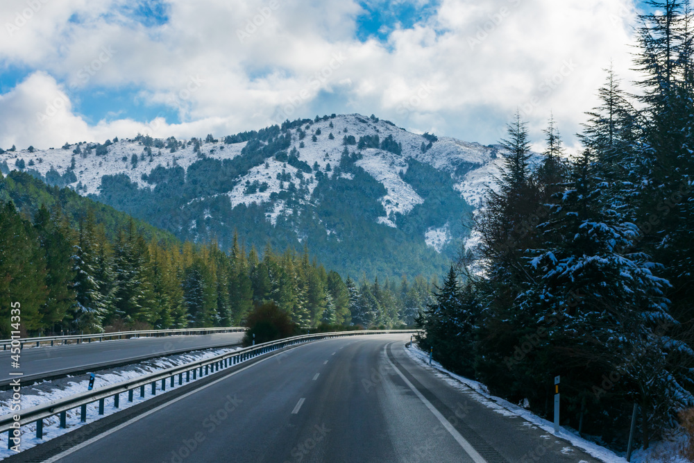 Highway between mountains and snow-covered forests. Highway between mountains and snow-covered forests.