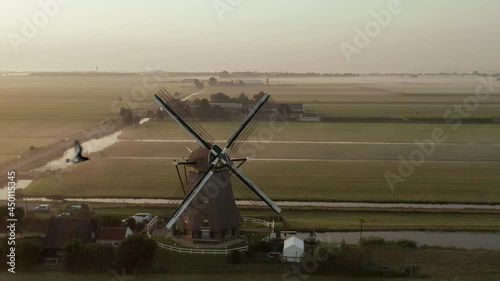 Classic Dutch windmill in early misty morning. Aarlanderveen, The Netherlands. Aerial orbit shot. photo