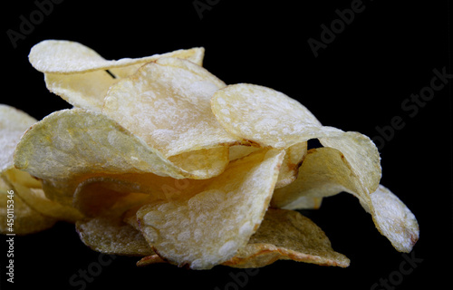 Delicious crispy potato chips on a black background.