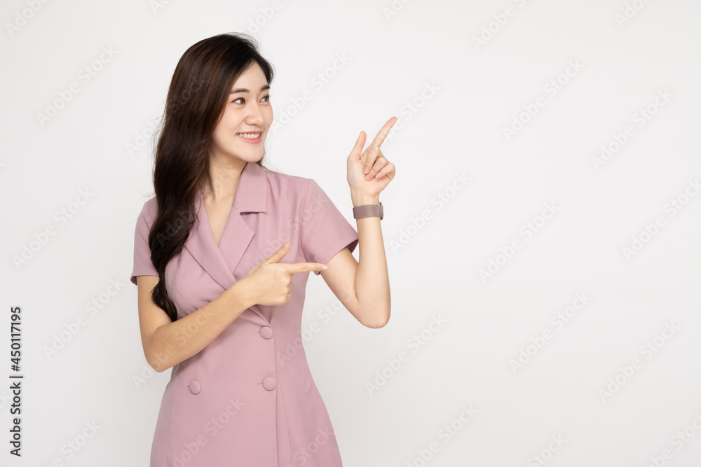 Young Asian woman smiling and pointing to empty copy space isolated on white background Young Asian woman smiling and pointing to empty copy space isolated on white background