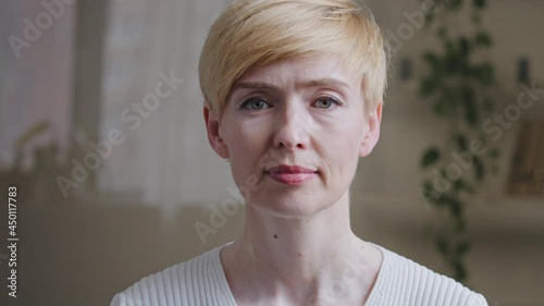 Portrait caucasian adult mature middle age 40s woman with short hair female face with natural make-up wrinkles skin posing looking at camera standing indoors, satisfied client of cosmetology service