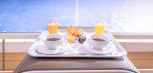 Tasses de café et petit déjeuner sur la terrasse d'une cabine balcon d'un navire de croisière, vue sur la mer.	 photo