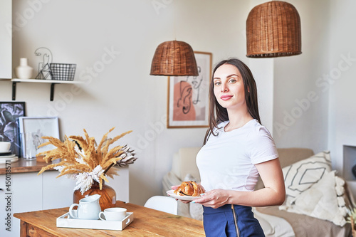 Young woman cooking in kitchen. Healthy Food. Fitness diet. Light kitchen interior. Girl smiling at camera. Portrait of housewife. photo