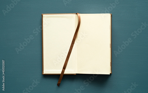 notebook with space for text, ecru-colored cards, brown bookmark, on a painted background, photo from above