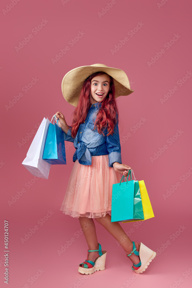 little caucasian child girl holds shopping bags