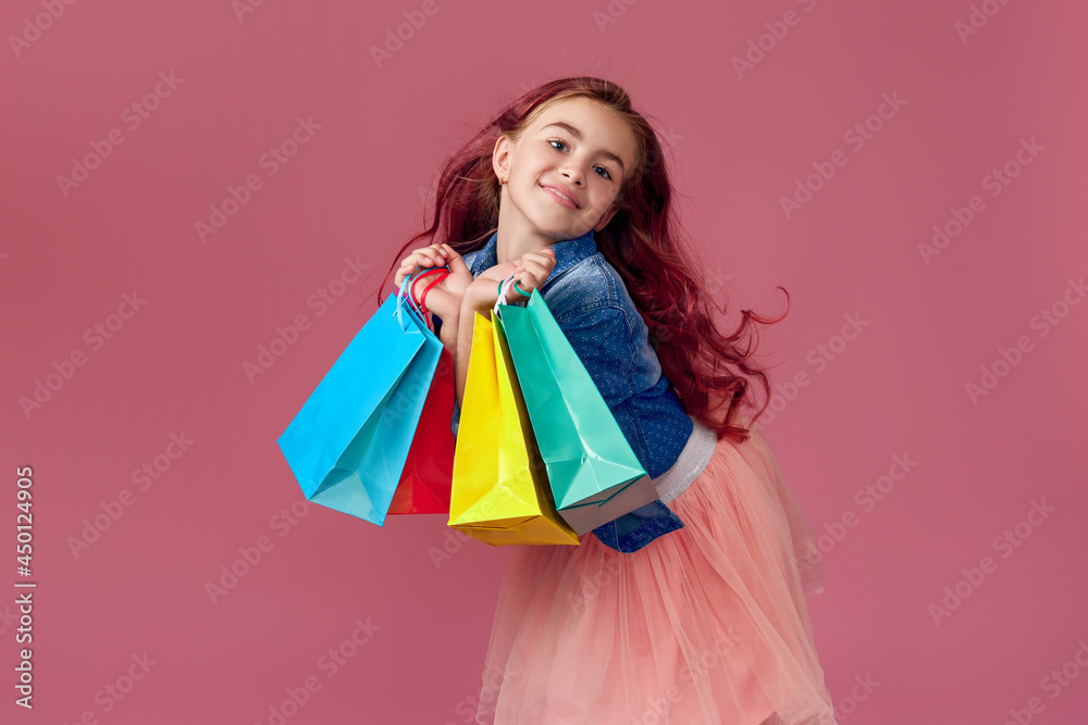 little caucasian child girl holds shopping bags