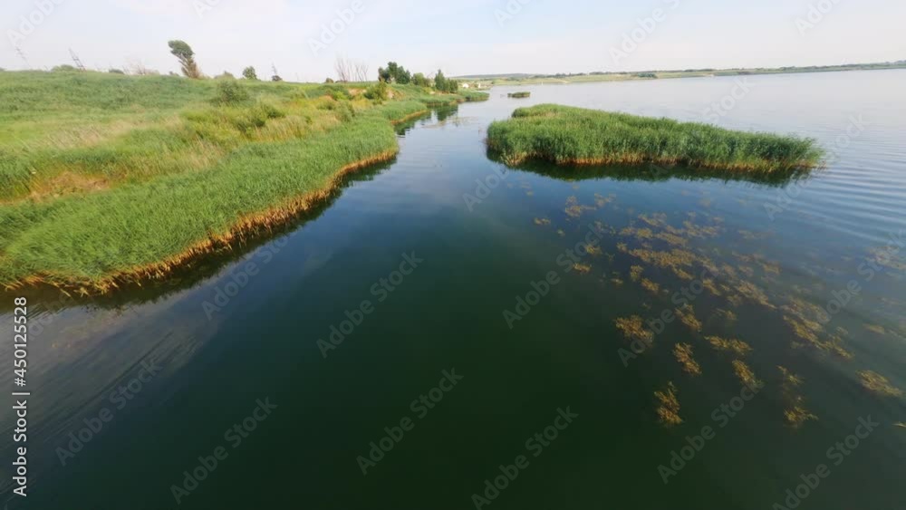 Birdseye FPV flight over stunning peaceful lake in summer season. Drone views of beautiful water, coastline and swimming birds. Countryside. Birdseye FPV flight over stunning peaceful lake in summer season. Drone views of beautiful water, coastline and swimming birds. Countryside.
