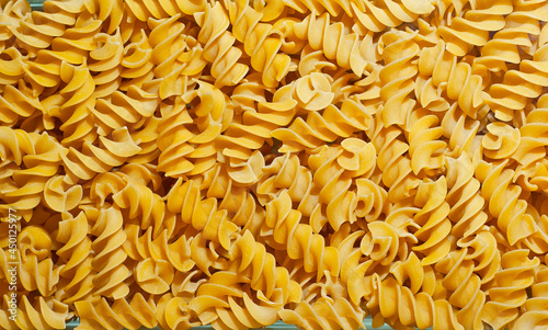 Pasta texture. Many yellow pasta are piled on the pile.