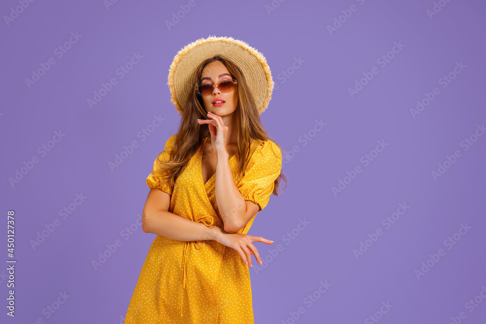Portrait of excited young woman in yellow dress, summer hat, sunglasses posing isolated on pastel violet background. Portrait of excited young woman in yellow dress, summer hat, sunglasses posing isolated on pastel violet background.