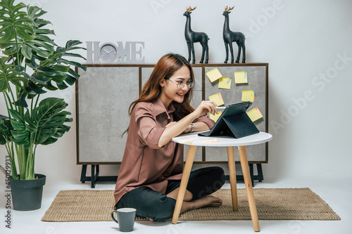 Young woman working from home with digital tablet and smartphone