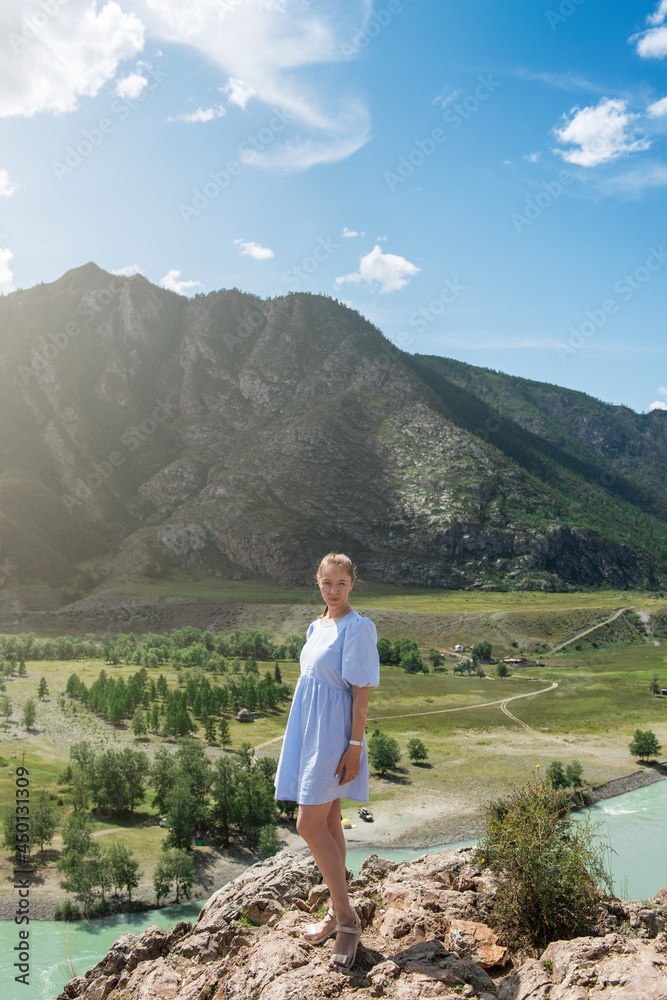 Naklejka premium Woman in blue dress on the confluence of two rivers Katun and Chuya in Altai mountains, beauty summer day