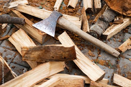 The ax lies on the wood. Firewood chopping. Preparation of firewood for the winter. Iron ax with wooden handle