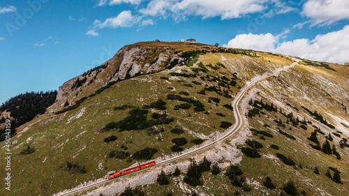 Schafbergbahn Cog Railway running from St. Wolfgang up the Schafberg, Austria.Journey to the top of Alps through lush fields and green forests.Beautiful mountain panorama.View of lake Wolfgangsee. photo