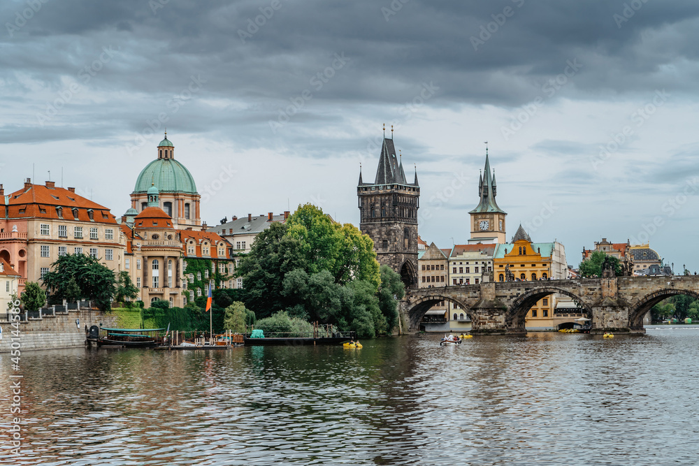 Charles Bridge,tourist boat on Vltava river,Prague, Czech Republic. Buildings and landmarks of Old town on summer day. Amazing European cityscape.Popular tourist destination.Colorful urban city scene