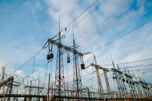 Electrical pylons and high voltage power lines are behind a barbed wire fence