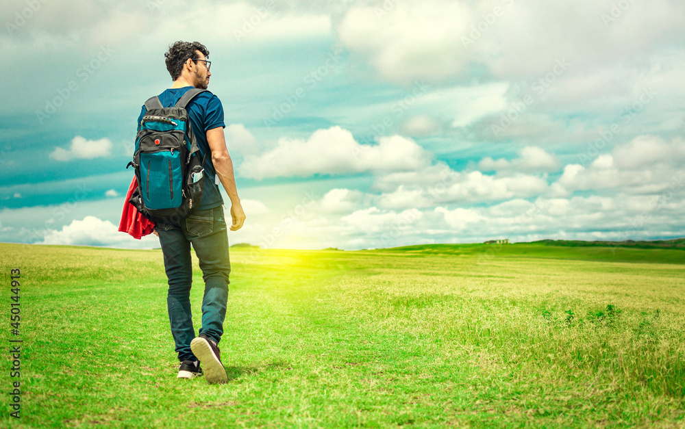 Adventurous man in the field, man with backpack in the field looking Adventurous man in the field, man with backpack in the field looking