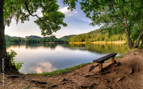 Картината върху платно Panoramatic photo of lake with bench