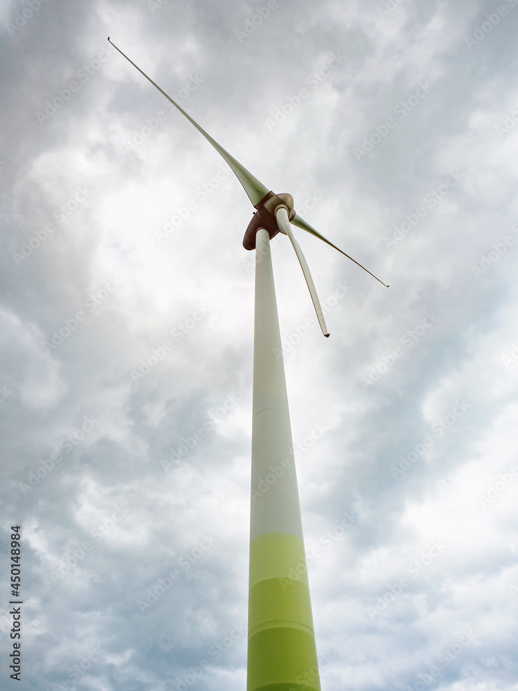 Wind turbines against cloudy sky in an open field Wind turbines against cloudy sky in an open field