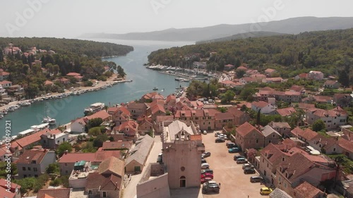 Aerial 4k video of the bay and old city with fortress and church in the town of Vrboska on Hvar island, Croatia