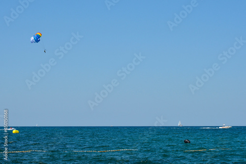A parascender, or parasailer, and a speed boat off the Adriatic Sea coastline in July north of Novigrad, Istria, Croatia
