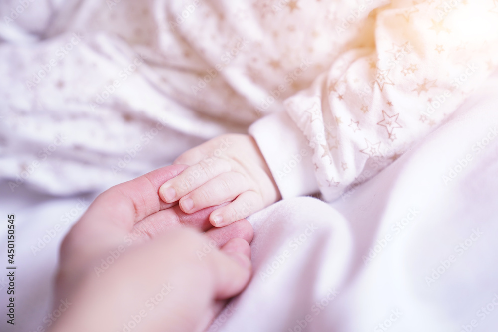 A newborn baby holds the mother's hand, a close-up of the child's hand in the mother's hand. High quality photo A newborn baby holds the mother's hand, a close-up of the child's hand in the mother's hand. High quality photo