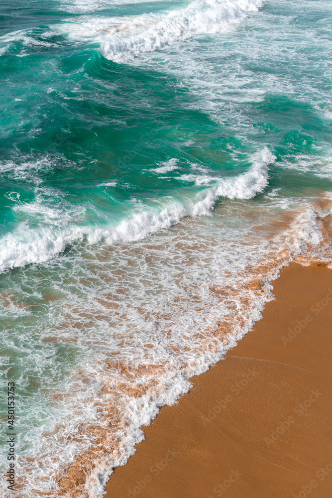 Aerial view of the ocean waves and beach. World Mother Earth Day. Blue water background. Sea top view. Atlantic Ocean beach with sand texture	