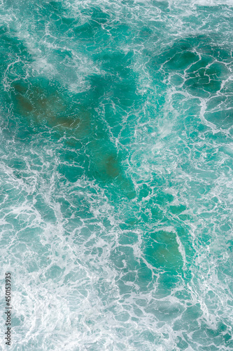 Aerial view of the ocean waves and beach. Blue water background. Sea top view. Atlantic Ocean beach with sand texture 